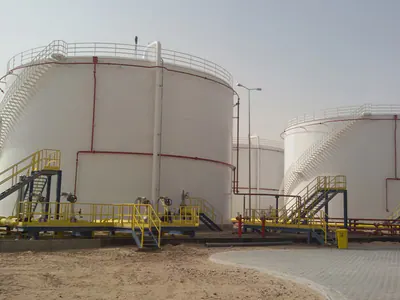 White storage tanks with spiral stairs and yellow platforms