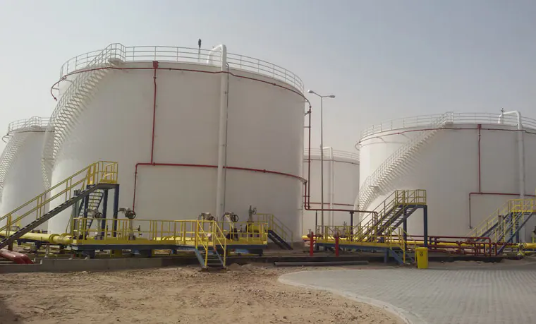 White storage tanks with spiral stairs and yellow platforms
