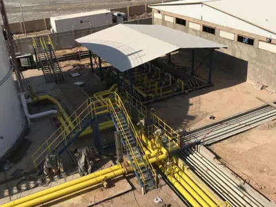 Yellow pipework and access platforms beside a canopy, seen from above