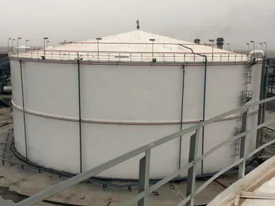 Large white cylindrical steel tank, seen from a neighbouring tank's roof