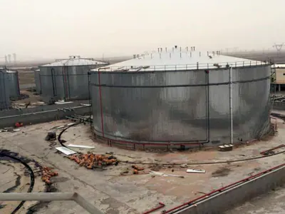 Tank clad in corrugated metal sheeting inside a bund wall, with more tanks behind