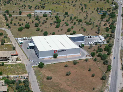 Logistics warehouse with loading bays and a vehicle yard, from the air