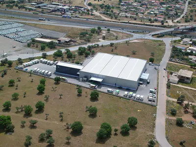 Logistics warehouse with a fleet of parked trucks, near a motorway
