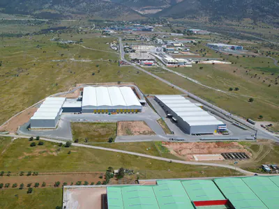 Warehouse buildings around a yard, with an industrial area behind