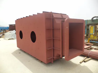 Red-primed rectangular steel duct with a flanged opening, in a yard