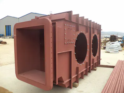 Red-primed steel duct with flanged openings, in a fabrication yard