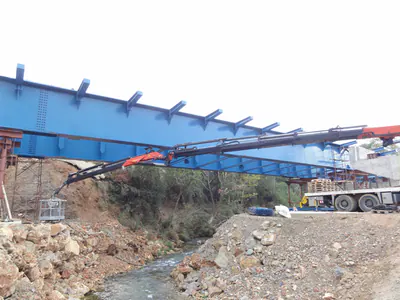 Blue steel bridge frame spanning a stream bed