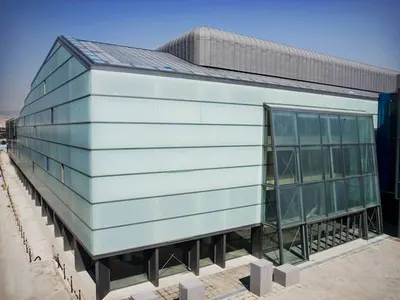 Building with pale frosted-glass cladding and a glazed corner
