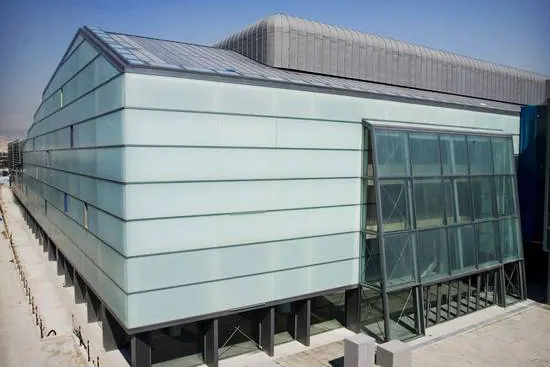 Building with pale frosted-glass cladding and a glazed corner
