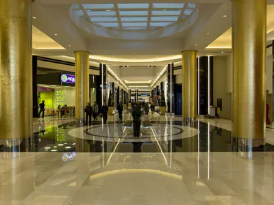 Shopping centre concourse with gold-coloured columns and oval ceiling glazing