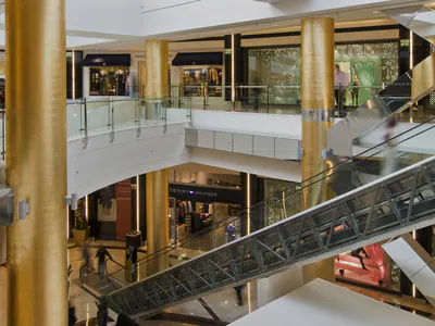 Escalator crossing an atrium between gold-coloured columns