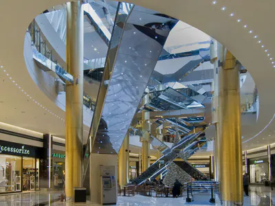 Circular atrium opening with gold-coloured columns and mirror-clad escalators