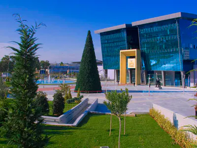 Glass-fronted building beyond landscaped gardens