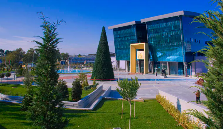 Glass-fronted building beyond landscaped gardens