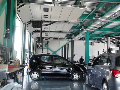 Car service workshop with teal steel columns and parked cars