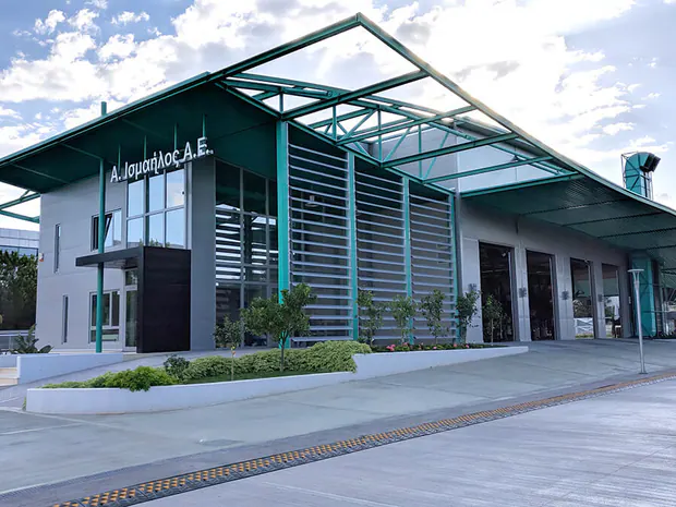 Two-storey building with a pitched teal steel canopy and a glazed front