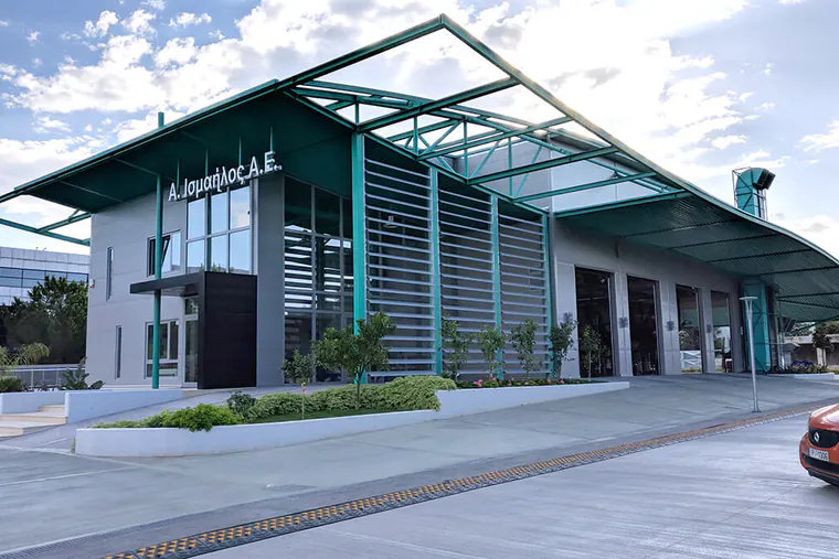 Two-storey building with a pitched teal steel canopy and a glazed front