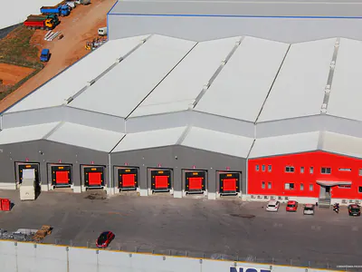 Warehouse front with red loading doors and a red office section, from above