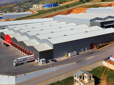 Warehouse with multiple pitched roofs and a truck at the loading side