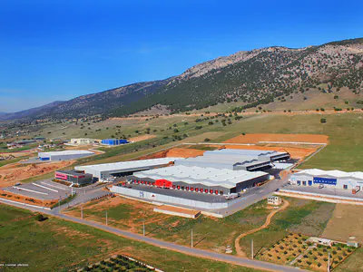 Warehouse complex in open land, mountains behind