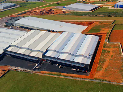 Large warehouse with multiple pitched roofs and loading docks, aerial view