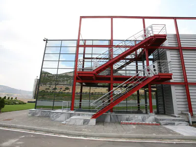 Red steel external staircase against a glazed facade