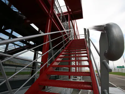 Red steel stair with steel handrails, looking up