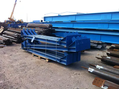 Blue steel members and pipes stacked in a yard