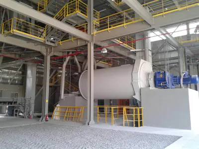 Plant interior with a grinding mill and steel platforms with yellow handrails