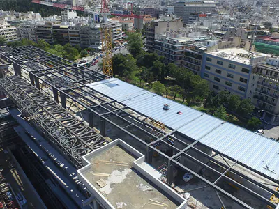 Long steel roof structure over a building under construction in the city, aerial view