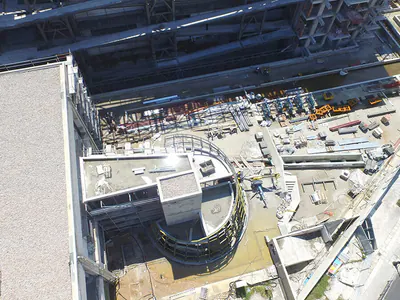 Construction site with a curved concrete structure, seen from above