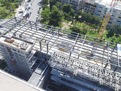 Steel framework on a building corner at a city junction, aerial view