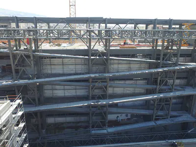 Sloping steel ramps and roof trusses spanning a building's interior