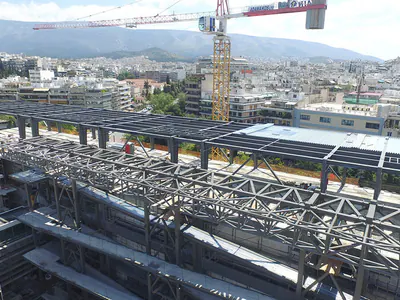 Steel roof trusses and a tower crane over a building under construction