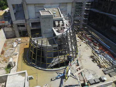 Curved steel-framed structure beside a stair core, seen from above