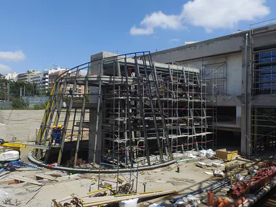 Curved steel framework with scaffolding on a construction site