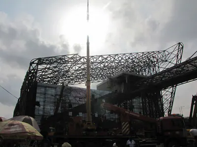 Steel space frame of a building's roof against a bright sky