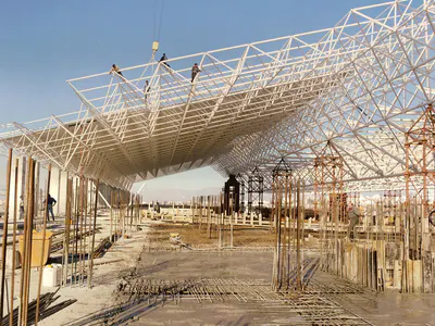 Large steel space frame lifted above a construction site