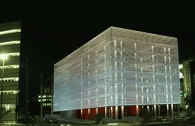 Cube-shaped building with a glowing striped facade at night