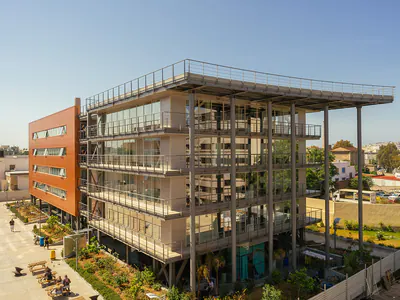 Multi-storey building with an exposed steel frame, balconies and a roof canopy
