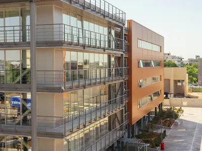 Multi-storey buildings with steel balconies along a paved walkway