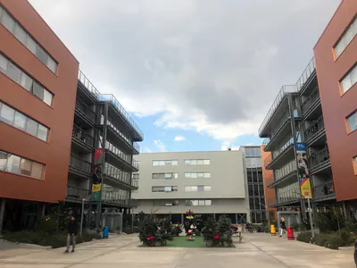 Courtyard between buildings with orange cladding and steel balconies