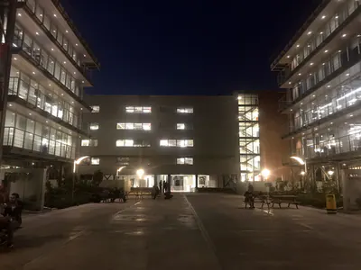 Buildings with steel balconies around a courtyard, lit at night