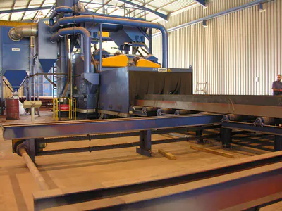 Shot-blasting machine with a roller conveyor in a production hall