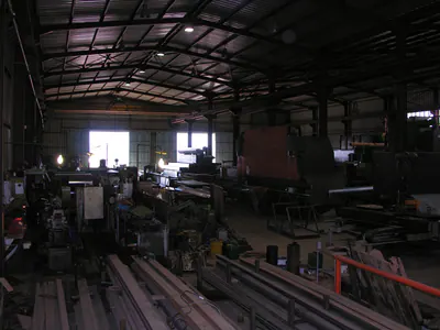 Interior of a production hall with machines and stacked steel sections