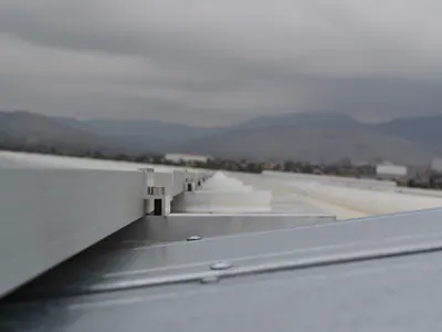 Χαμηλή λήψη στην άκρη συστοιχίας πάνελ, με βουνά στο βάθος