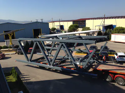 Long steel truss on a trailer outside a workshop