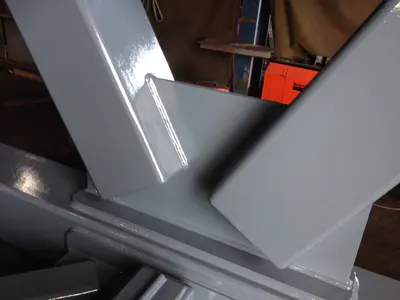Close-up of a welded joint in a grey steel truss