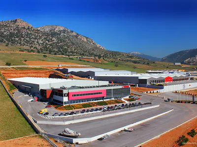 Warehouse with a glazed office front and a car park, aerial view