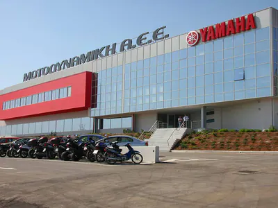 Glass-fronted office building with the Motodynamiki and Yamaha signs, motorcycles parked in front